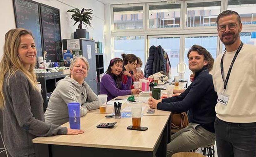 Membres d'un club Herbalife réunis autour d'une table avec leur coach
